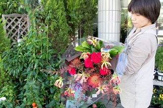 大人の雰囲気の色合いの、バラの赤が際立つ大きくボリュームのある花束です。