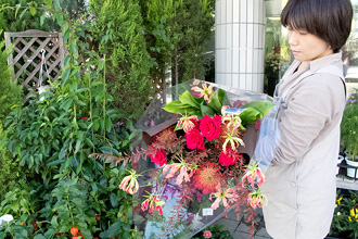 大人の雰囲気の色合いの、バラの赤が際立つ大きくボリュームのある花束です。